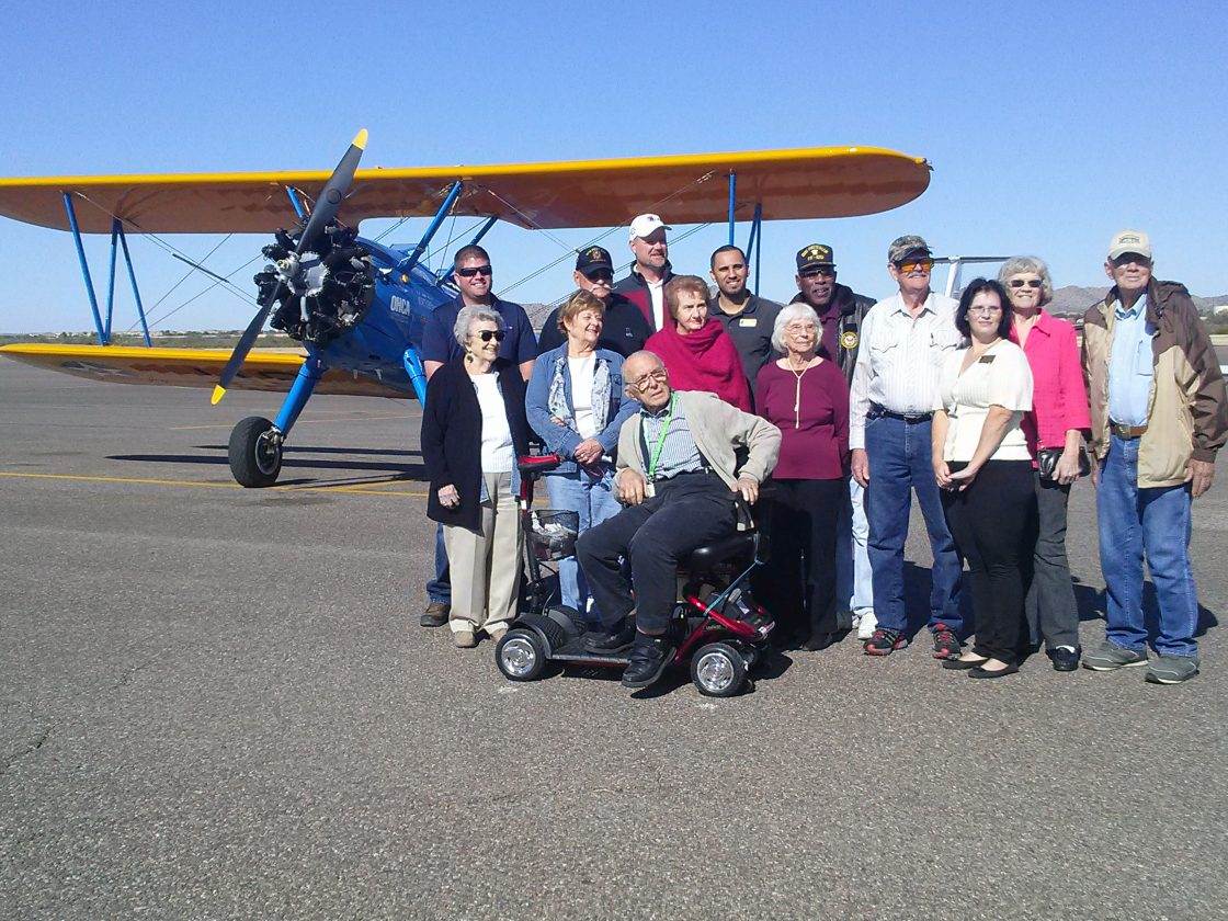 A group of seniors standing in front of a small propellor plane