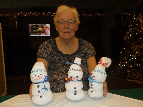 Linda displays her sock snowmen.