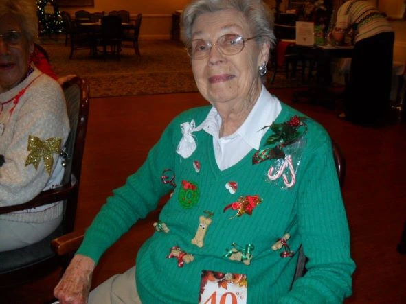A senior woman smiling wearing a Christmas sweater
