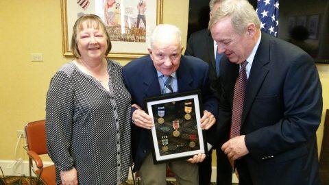 man holding war medals