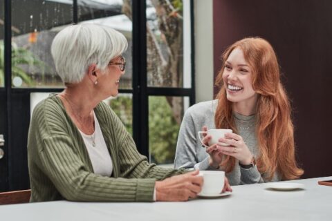 A woman speaks to her senior mother about care options.