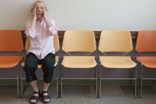 A woman with a sinus headache waits for a consultation with a doctor.