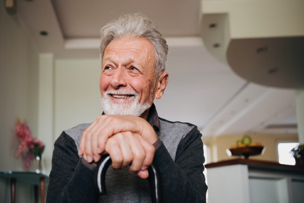 A senior man with arthritis smiles