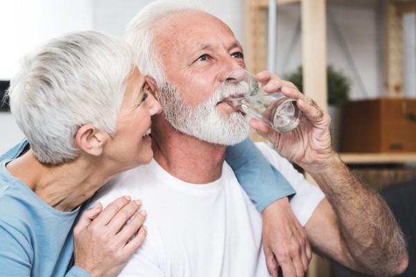 Senior couple drinking water indoors