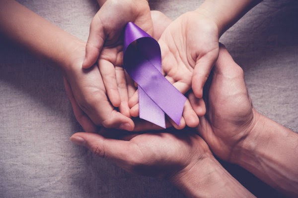 hands holding a purple alzheimer's ribbon