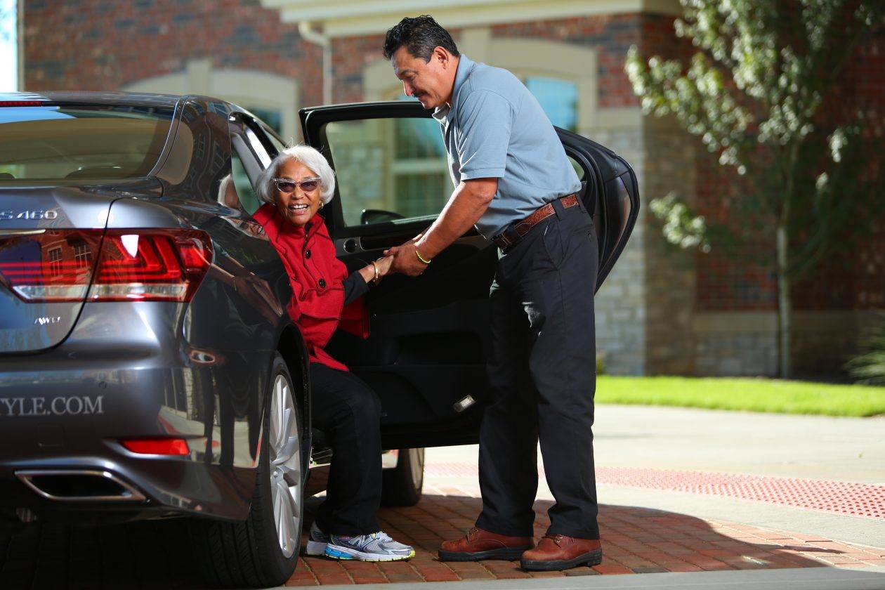 helping woman out of a car