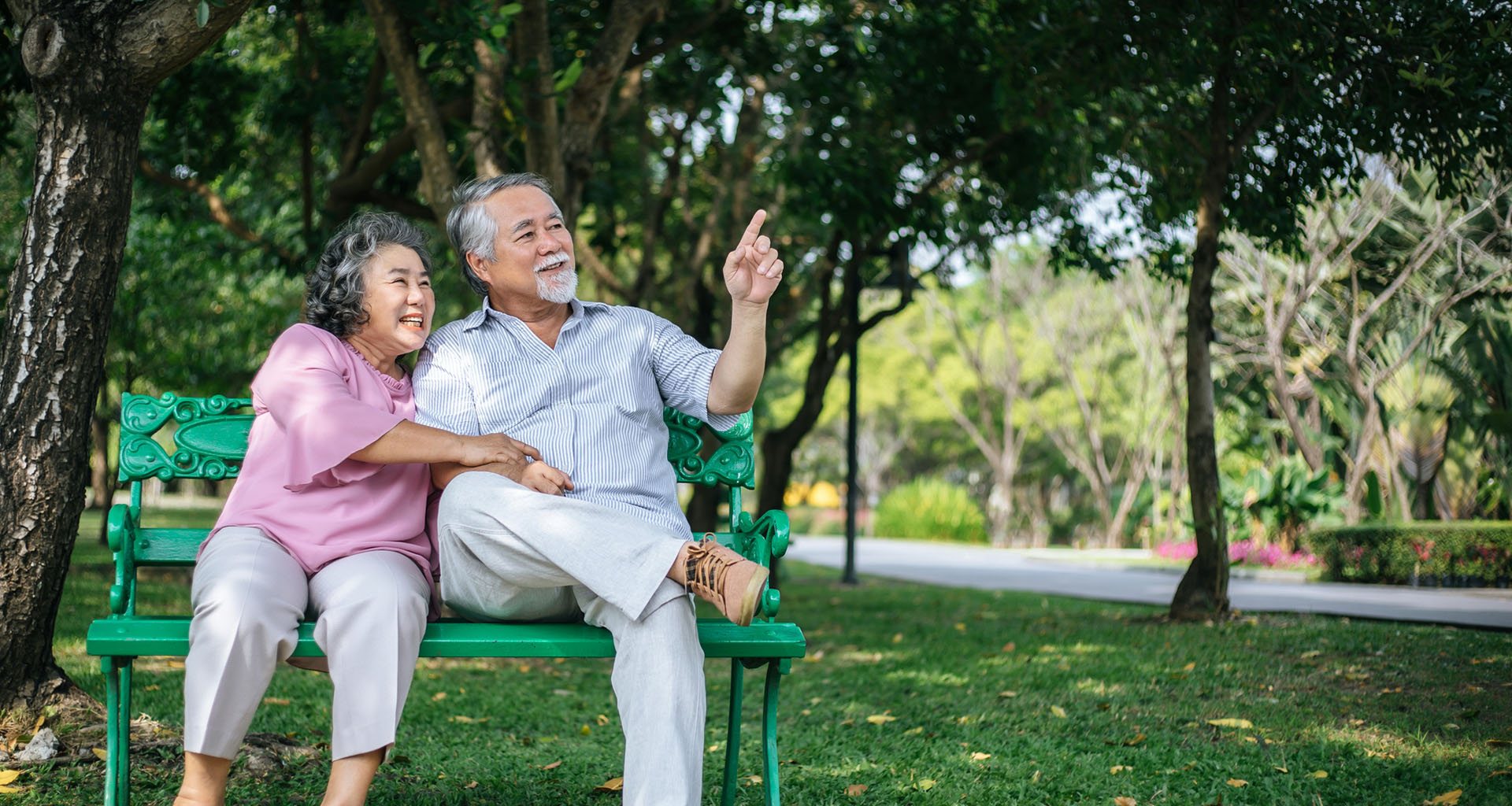 healthy senior couple relaxing seats on the bench in the park