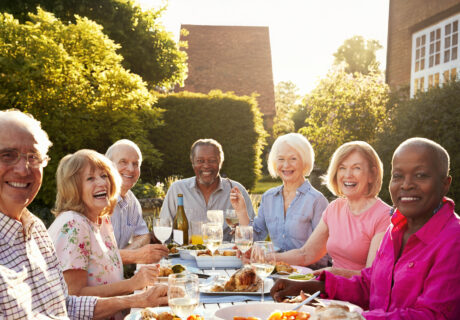 Portrait Of Senior Friends Enjoying Outdoor Dinner Party At Home