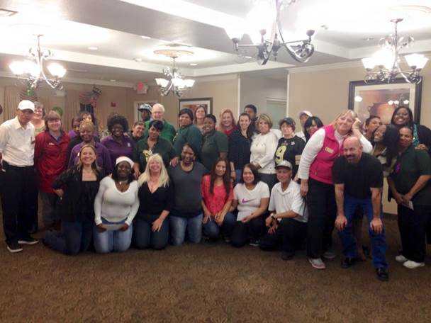 The President of the Resident Council, Mr. Andy Anderson (green shirt, just left of center) celebrates with employees at the Christmas Party.