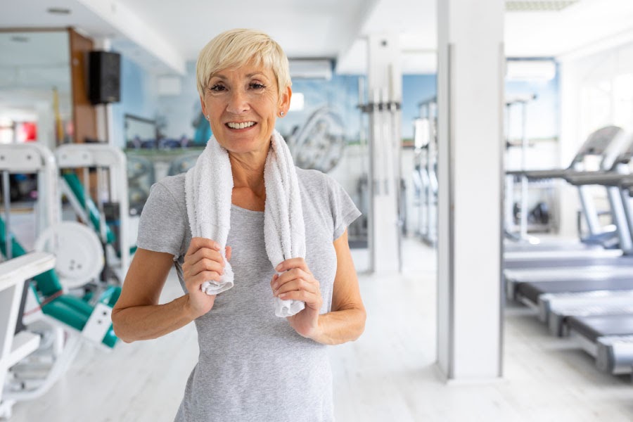This image has an empty alt attribute; its file name is fit-older-woman-smiling-in-a-gym-after-a-workout-1.jpg