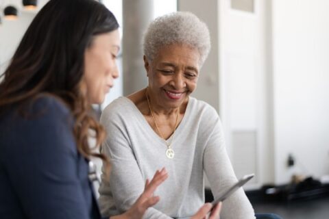 A senior and caregiver reviewing a message together to identify potential online scams.