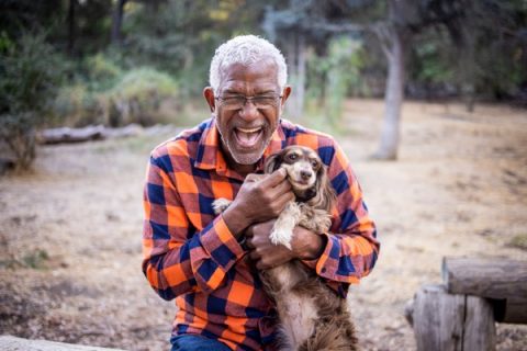 A senior cuddles his dog, one of the best pets for seniors.