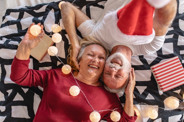 Older adult couple smiling with a holiday themed background