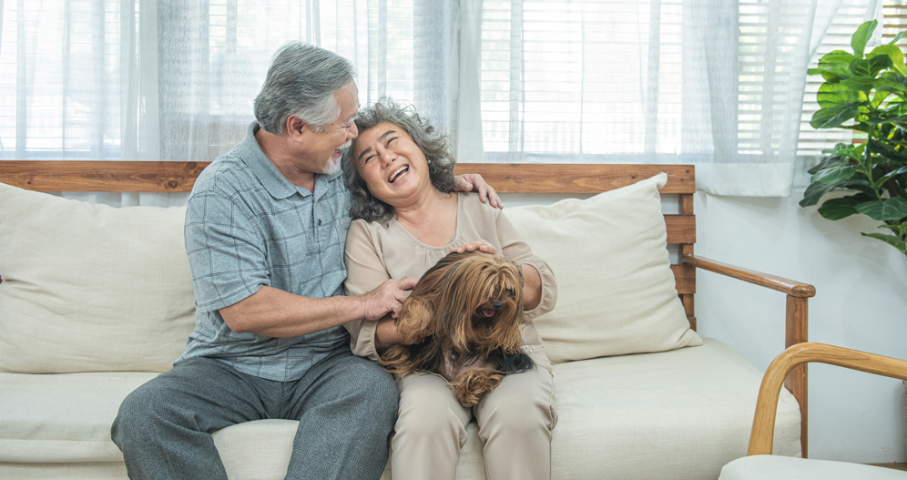 Image of a senior couple relaxing with their dog.