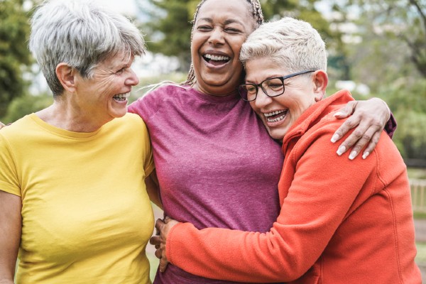 3 older adult women hugging outside