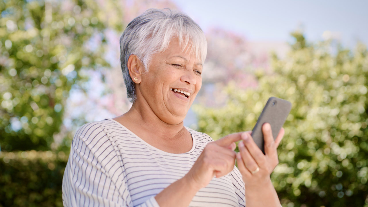 Senior lady smiling while on her phone