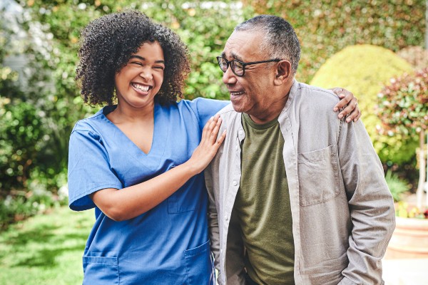 A senior shares a happy moment with his nurse at an assisted living community.