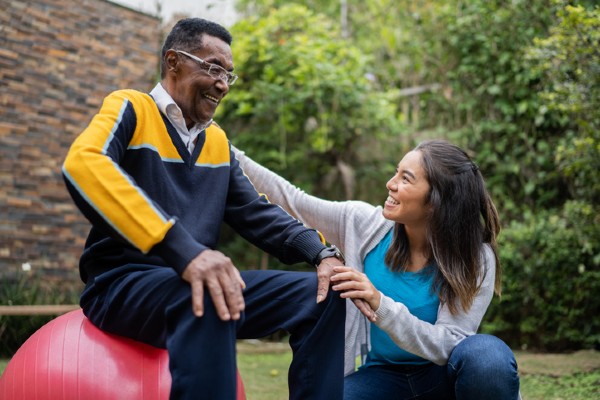 A senior man gets help with physical therapy.