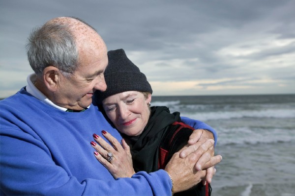 A senior couple embraces on a North Carolina beach