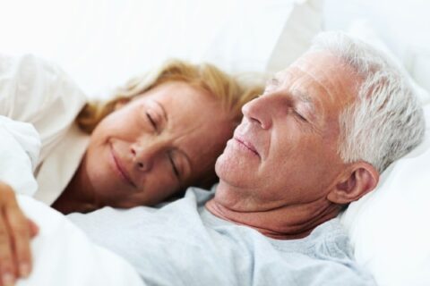 A senior couple sleeps soundly.