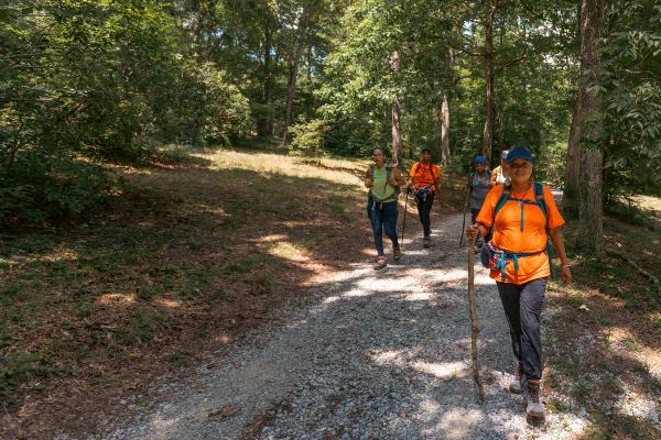 A senior woman joins hikers in the woods in Georgia.