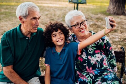 A young boy takes a selfie with his grandparents at their senior community.