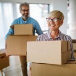 A happy older couple gets some boxes ready for the move.