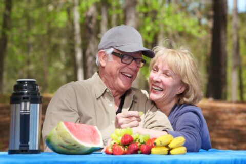 A senior couple has a fun lunch in a Georgia park.