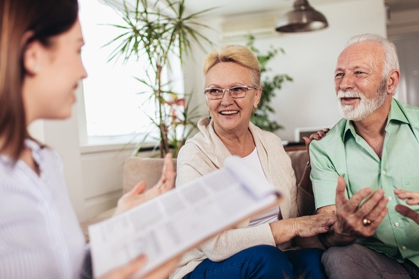 An insurance agent explains insurance choices to a senior couple.