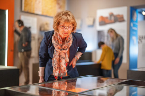 Smart Senior Caucasian Female Visiting A Museum And Being Fascinated By The Historical Findings