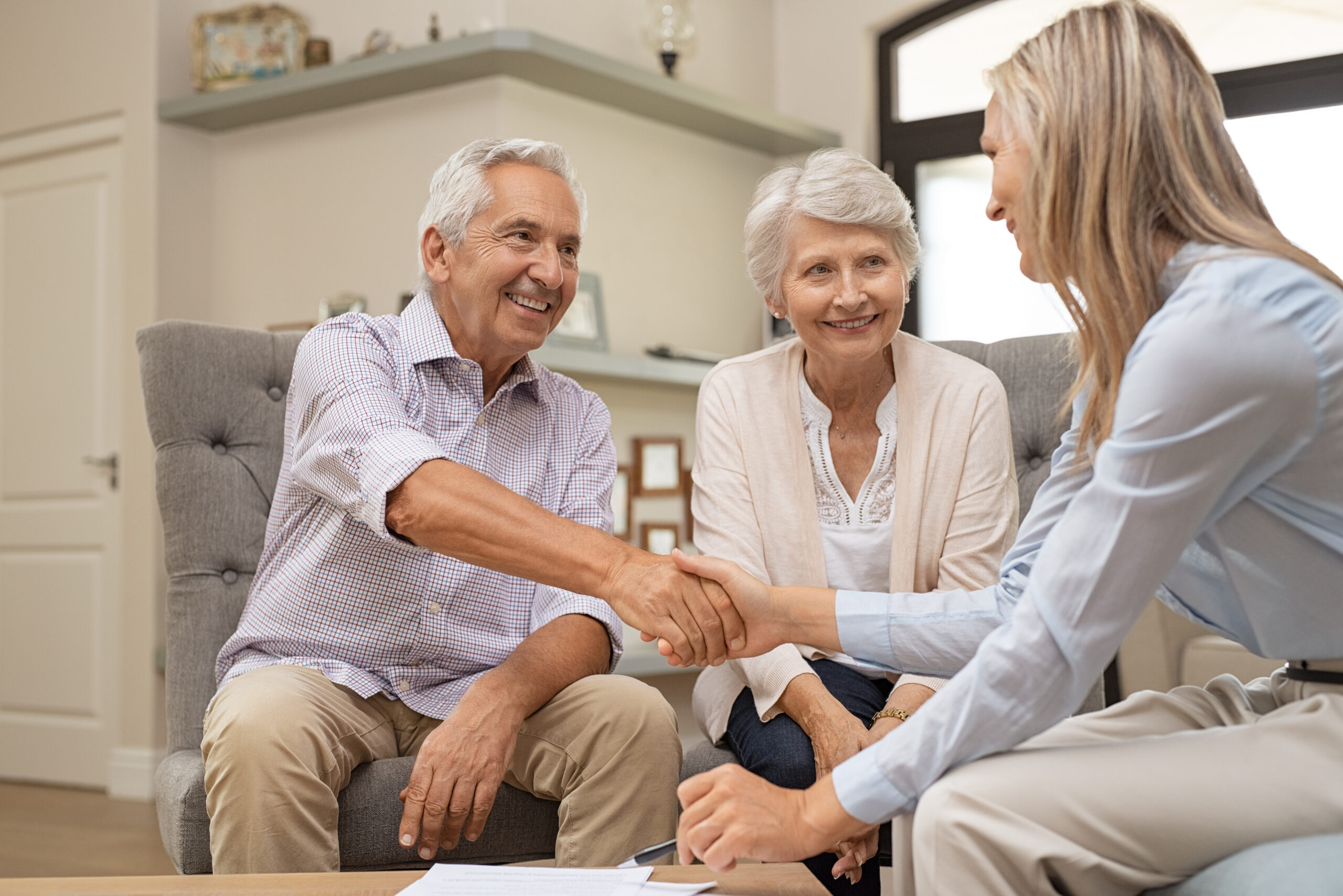 Senior couple shaking hands with financial advisor