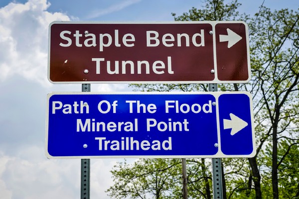 A road sign points to two sights to see in Johnstown: Staple Bend Tunnel and Path of the Flood Trail.