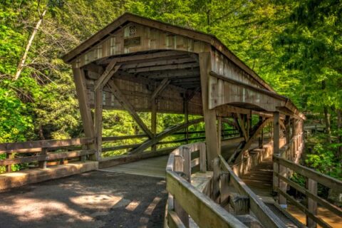 A picturesque covered bridge at Lanterman Falls welcomes visitors in Youngstown, OH.