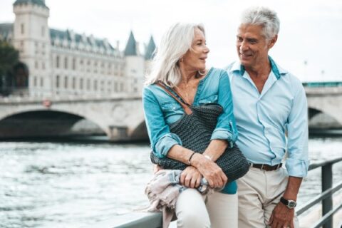 A senior couple enjoys a quiet moment in Paris along the Seine.