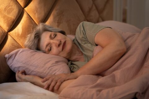 Senior woman can be seen sleeping soundly in bed.