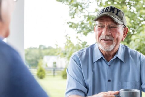 Retired Army veteran enjoys morning coffee with his wife outside.