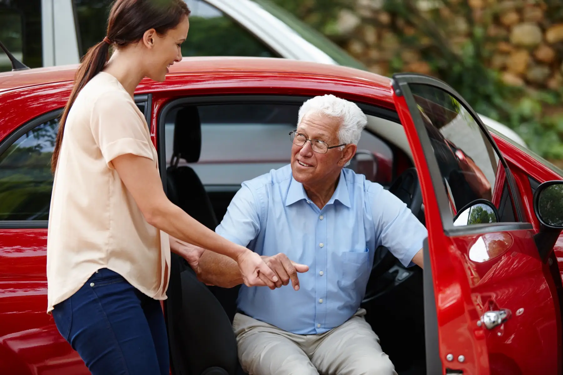 Let me help you out of the car Shot of a woman helping her senior father out of the car