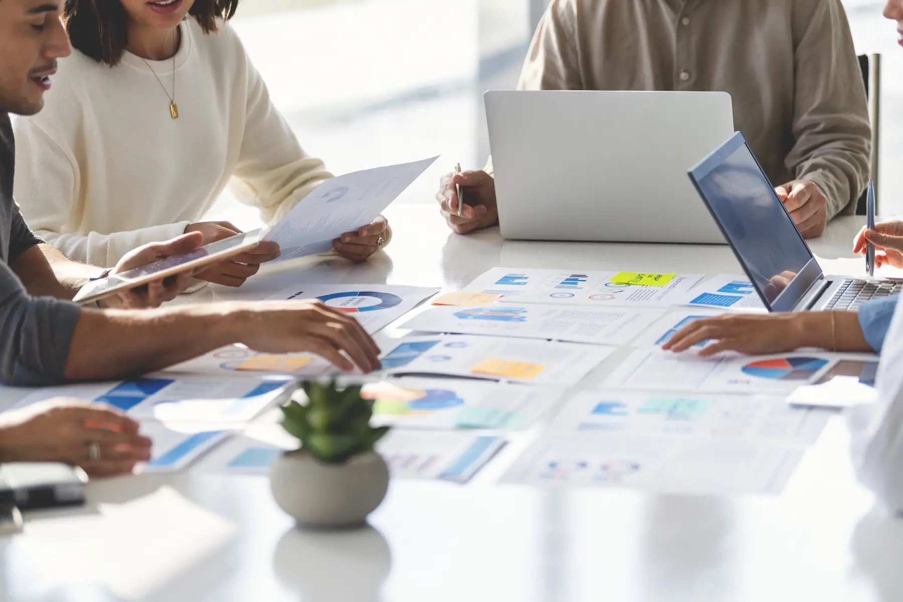 Multi racial group of people working with Paperwork on a board room table at a business presentation or seminar. Multi racial group of people working with Paperwork on a board room table at a business presentation or seminar.