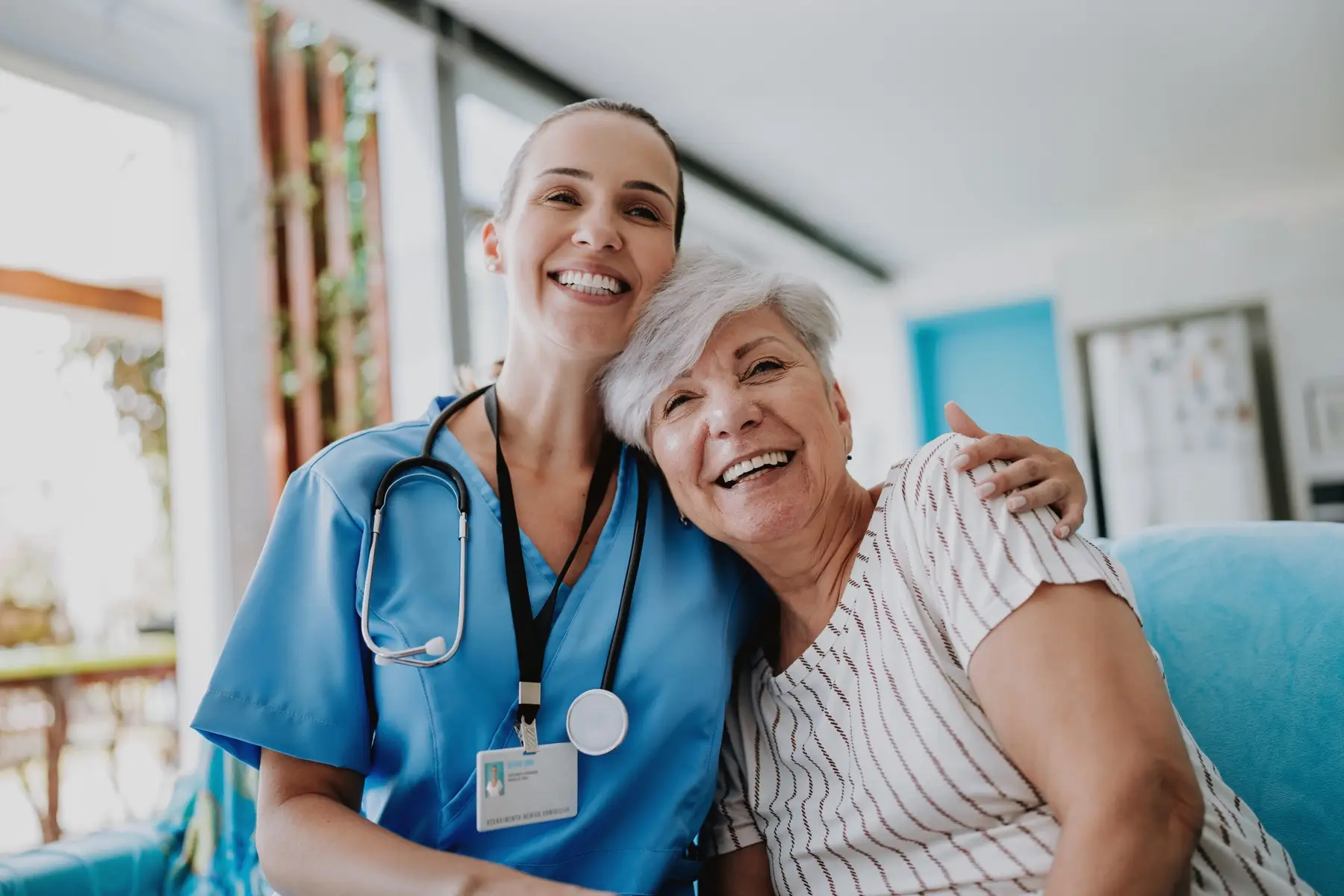 Home care healthcare professional hugging senior patient