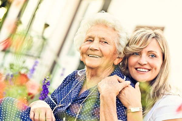 A senior and caregiver enjoy a moment.